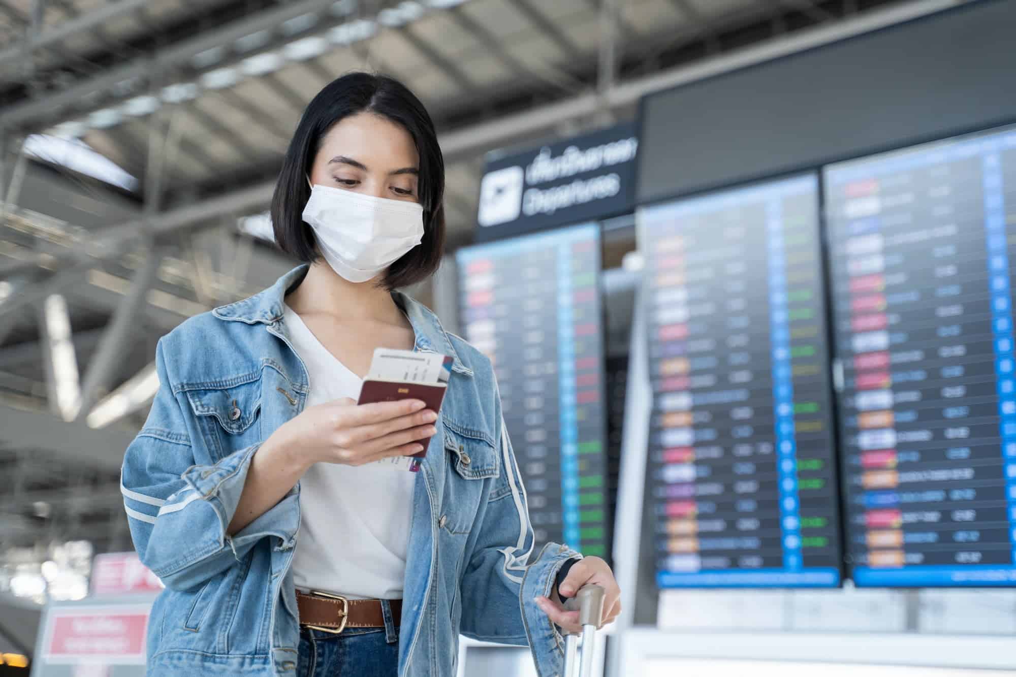 Caucasian woman passengers wear face mask walking in airport terminal.