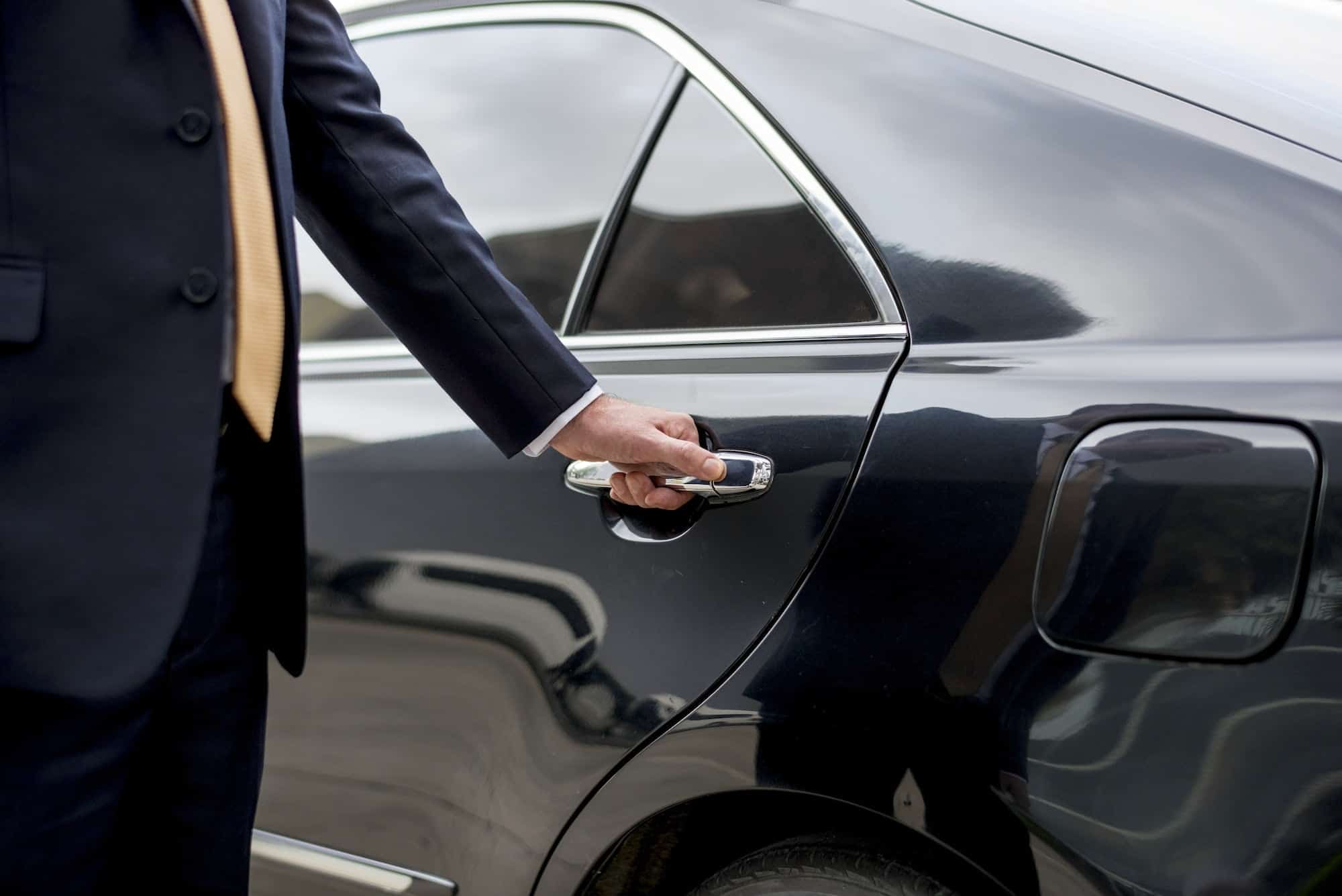 Limousine Chauffeur Opening Door For Guest
